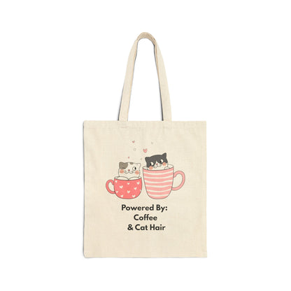 Tote bag with cartoon cats in coffee cups and text 'Powered By: Coffee & Cat Hair' on a white background