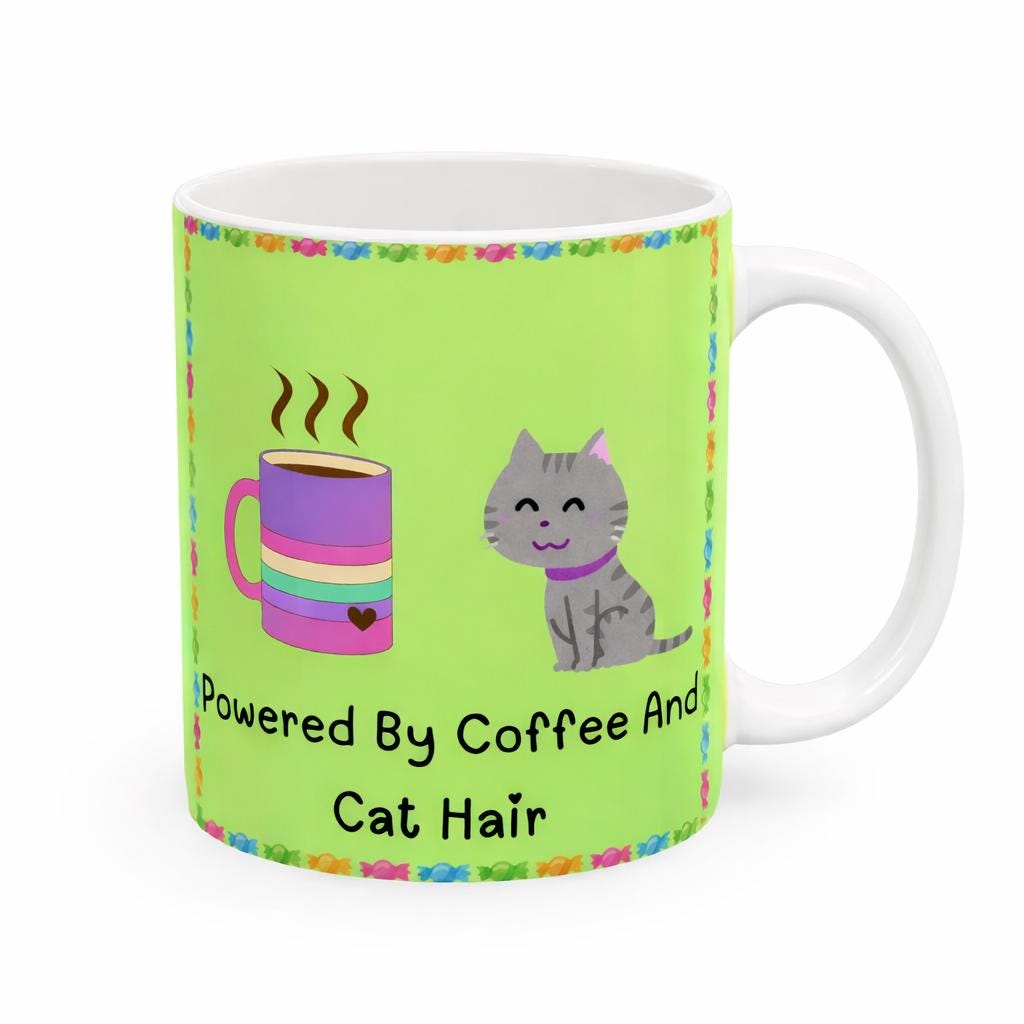 Green mug with a cat and coffee cup illustration and text 'Powered By Coffee And Cat Hair' on a white background