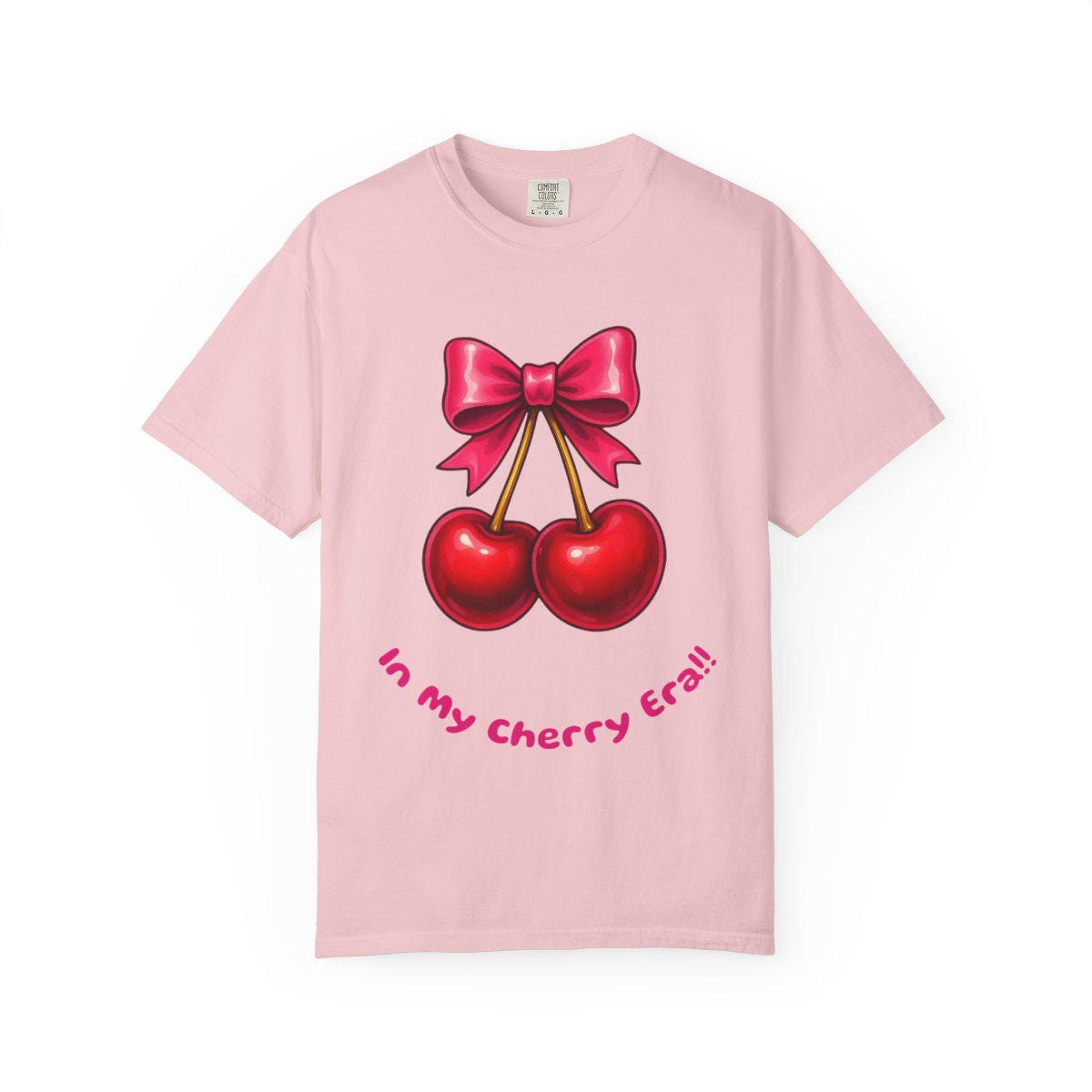 Pink t-shirt with cherry design and text on a white background