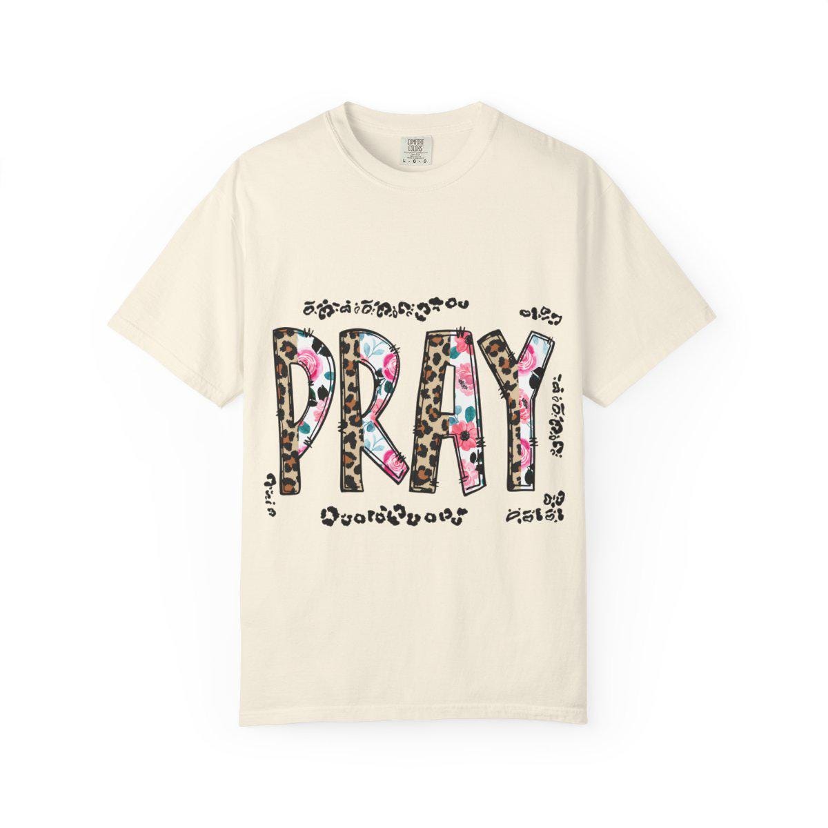 Beige t-shirt with 'PRAY' design featuring leopard print and floral patterns on a white background