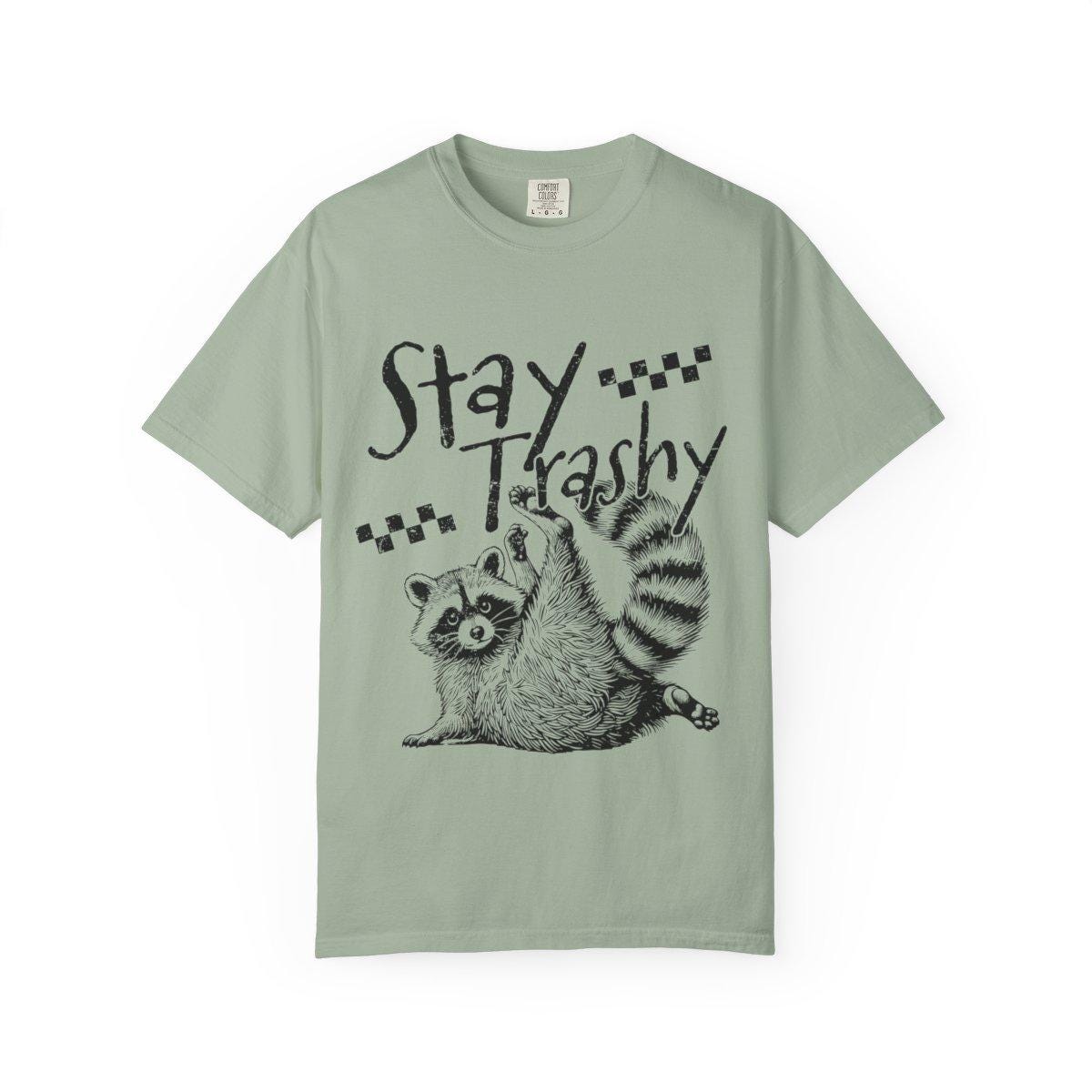 Mint green t-shirt with a raccoon graphic and 'Stay Trashy' text on a white background